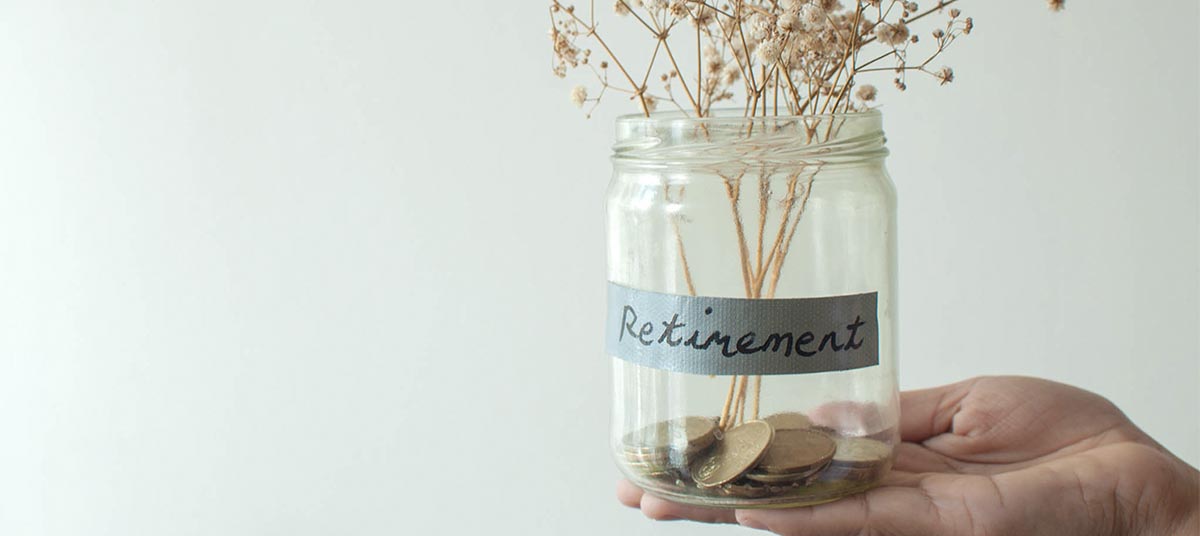 Hand holding jar for retirement savings
