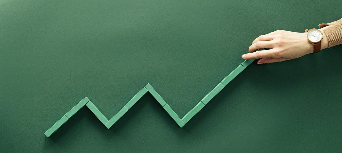 Person shaping upward trend with blocks