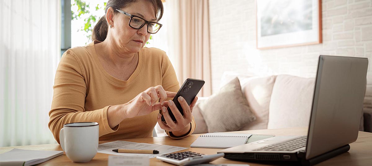 Female checking phone with coffee nearby
