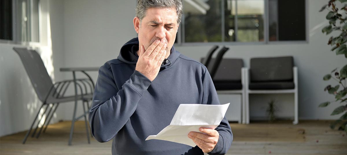 Man reading a surprising letter outdoors