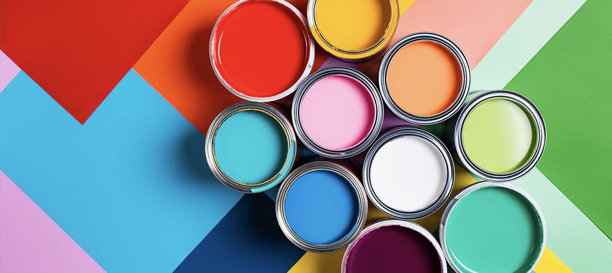 Colorful paint cans on vibrant geometric background.