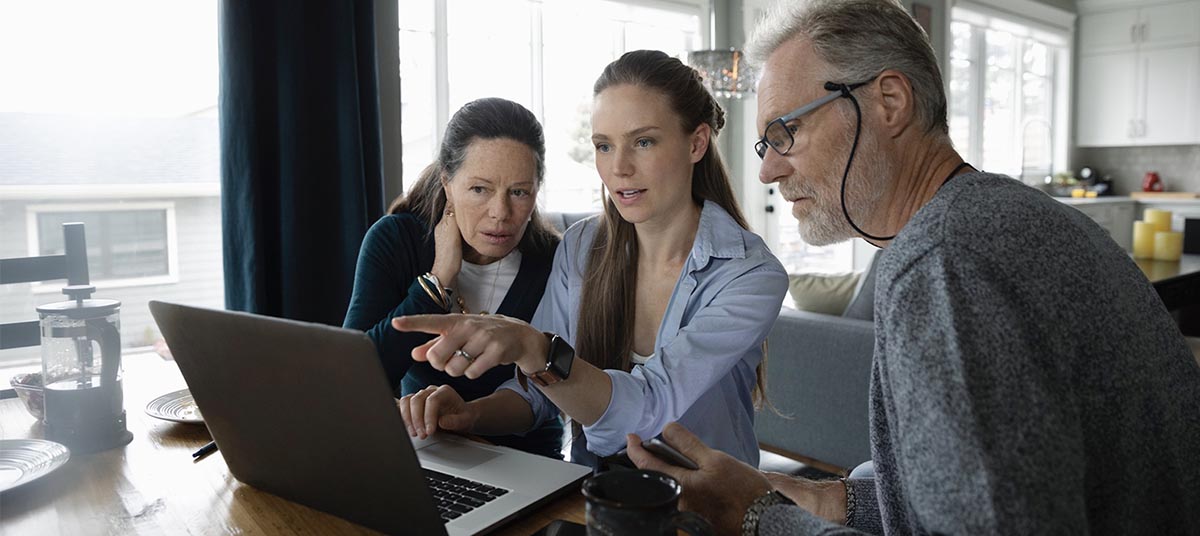 Family gathered around a laptop