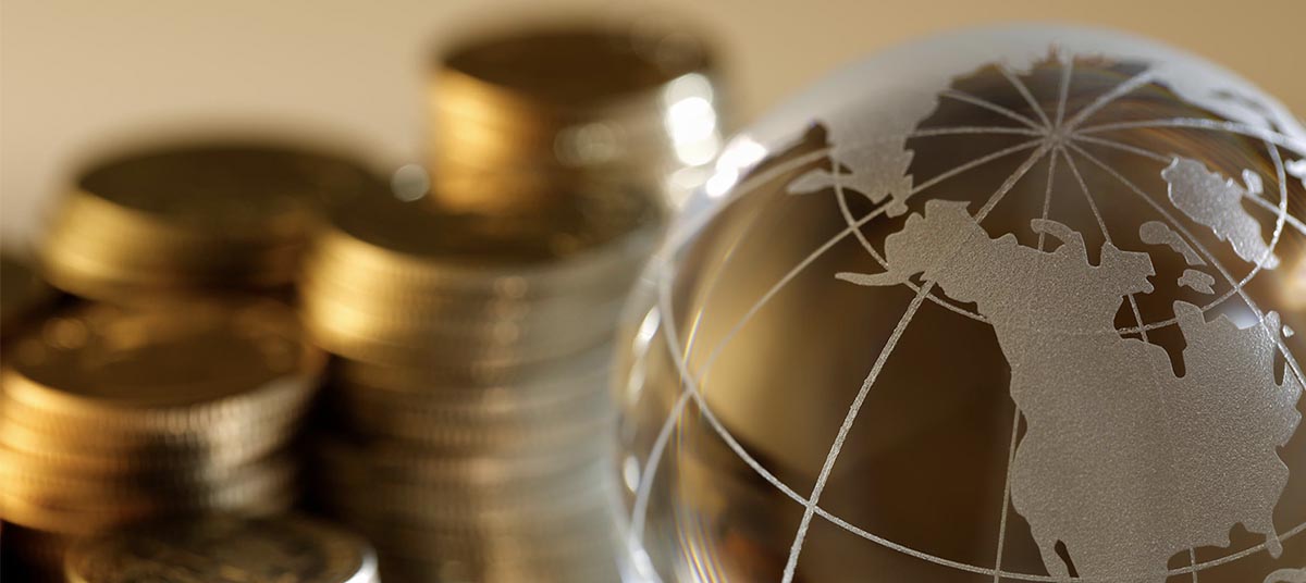 World map on glass globe with coins