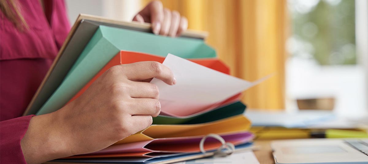 Hands sorting papers in folders