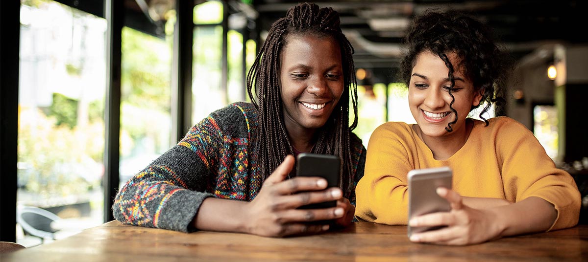 Happy duo looking at phones together