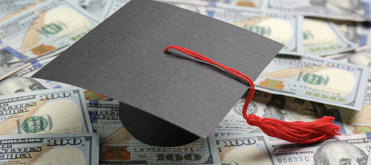 Education costs symbolized by cap and cash