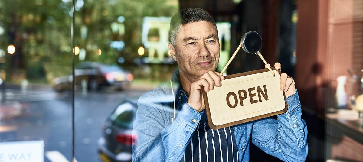 Businessman opening shop with sign