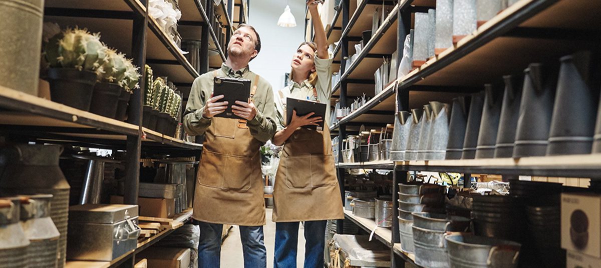 Two employees with tablets in stockroom