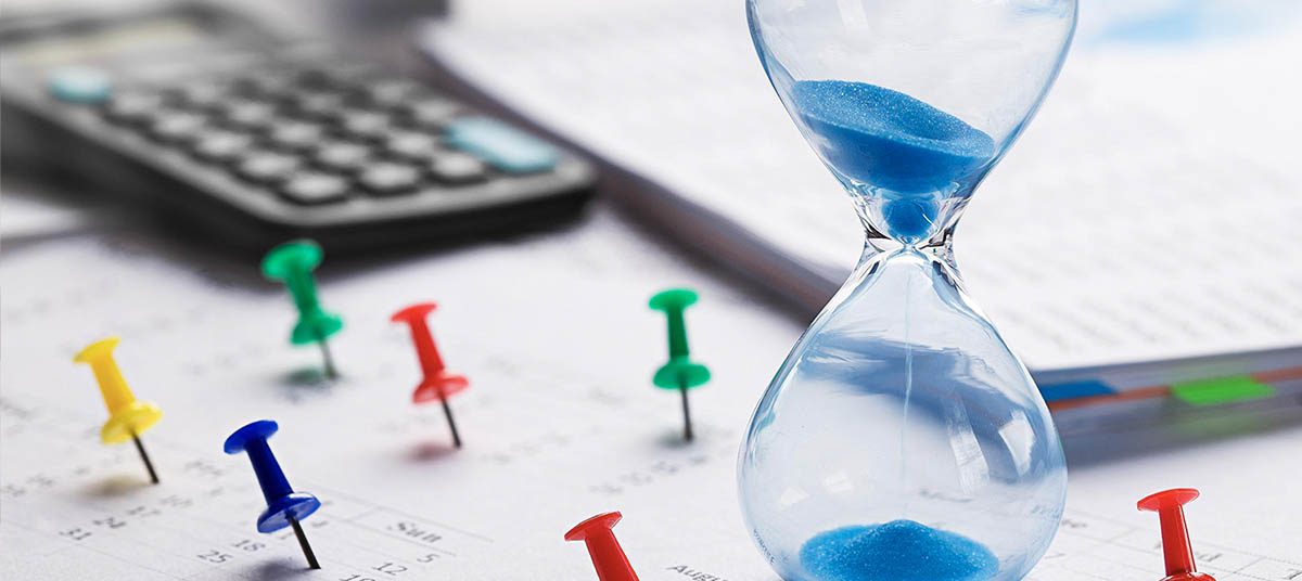 Calculator and hourglass on paperwork