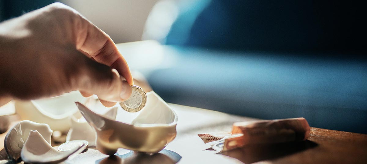 Coin and cash by broken piggy bank