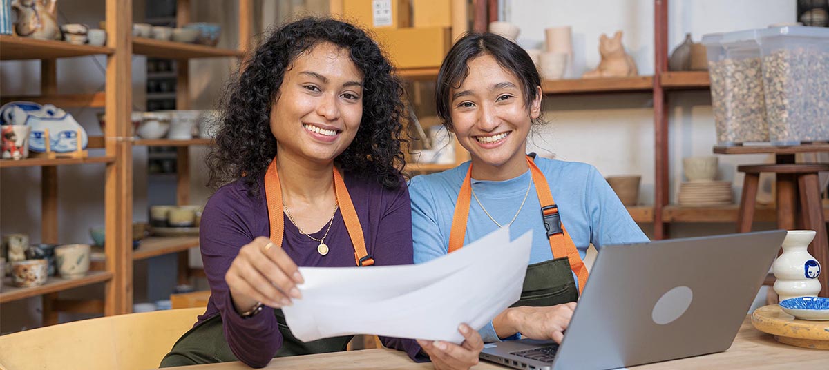Smiling women in aprons at table