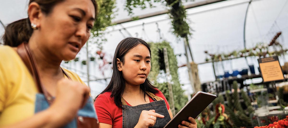 Two women focused on plant care