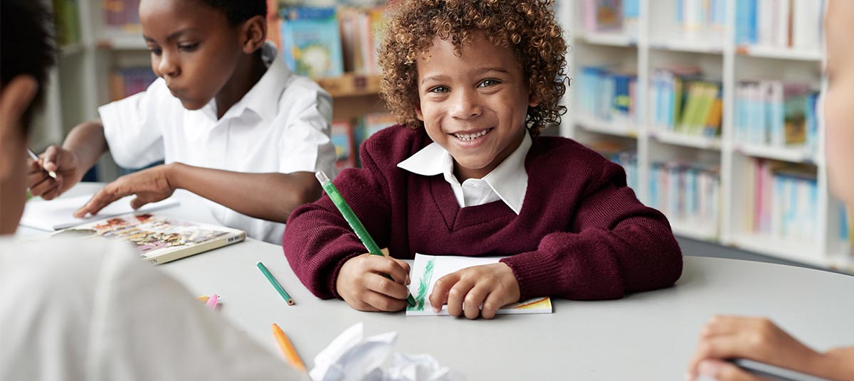 Child drawing happily in classroom