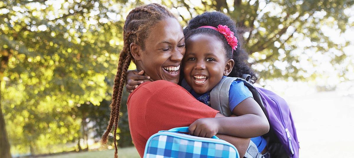 Mother and daughter hugging outdoors