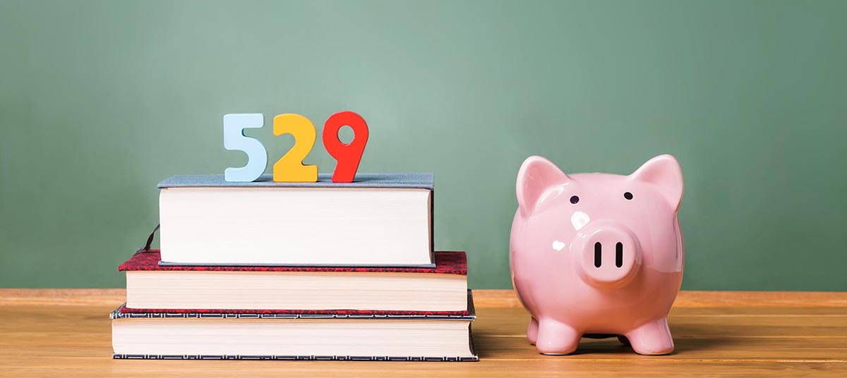 Stack of books, piggy bank, 529 numbers