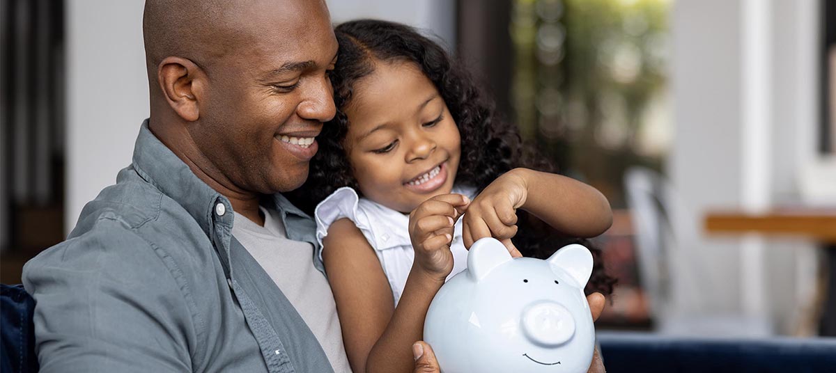 Smiling child saving money with dad