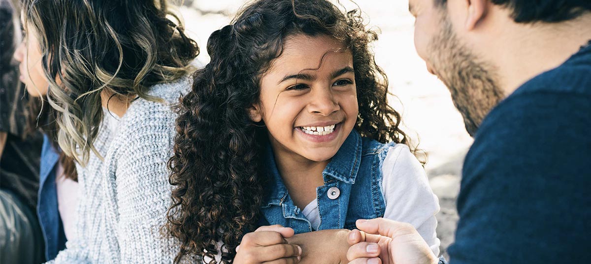 Smiling child holding dad's hands