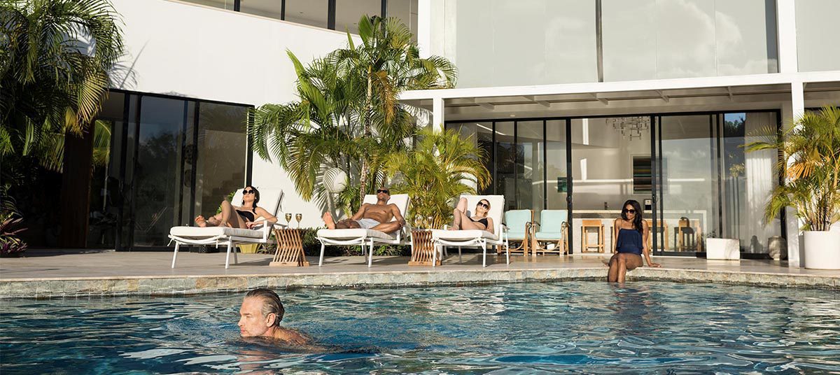 Friends lounging near a contemporary glass house