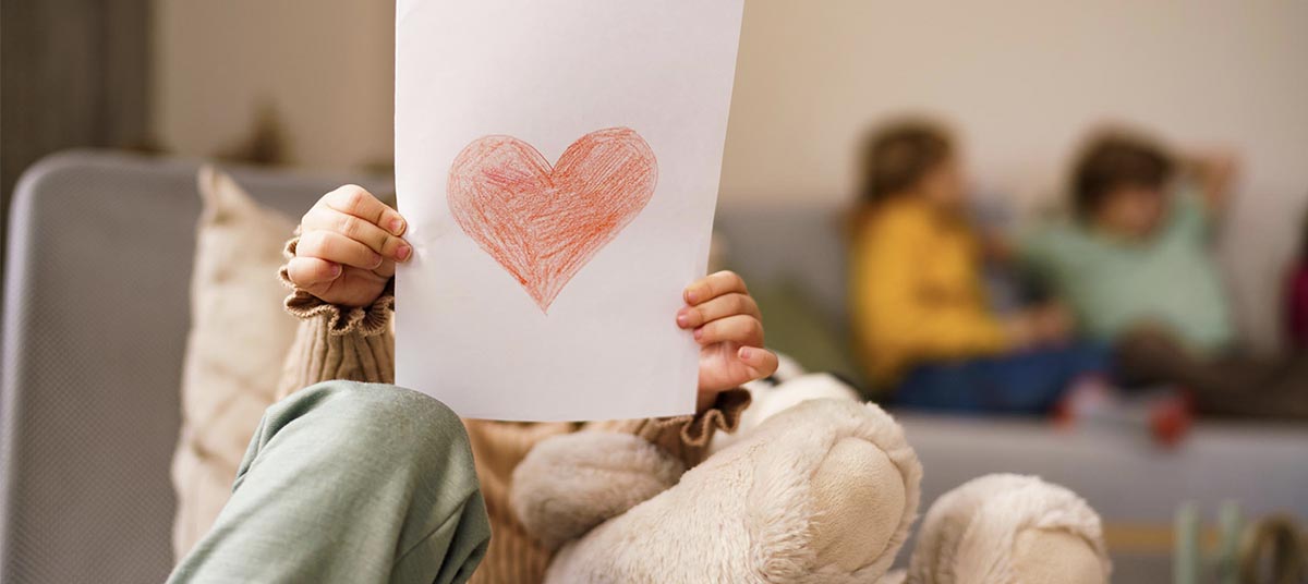 Child holding heart drawing