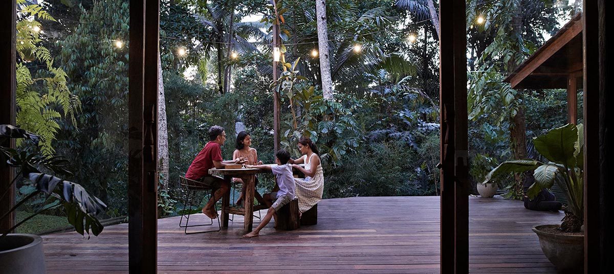 Family dining on outdoor deck at dusk