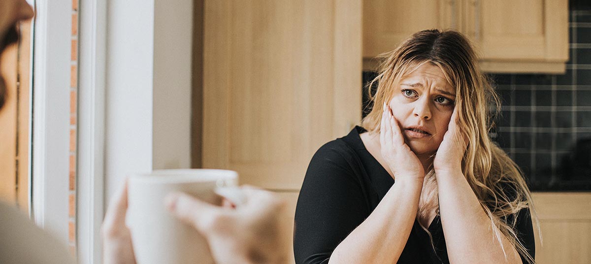 Woman looking concerned in the kitchen