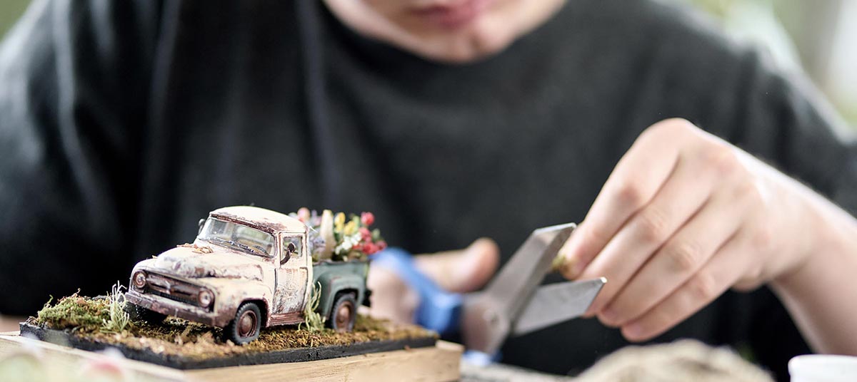 Miniature truck scene with hands working