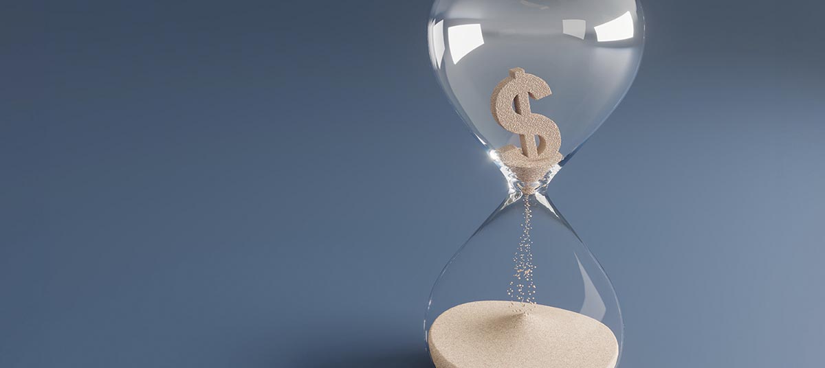 Sand flowing in hourglass with dollar