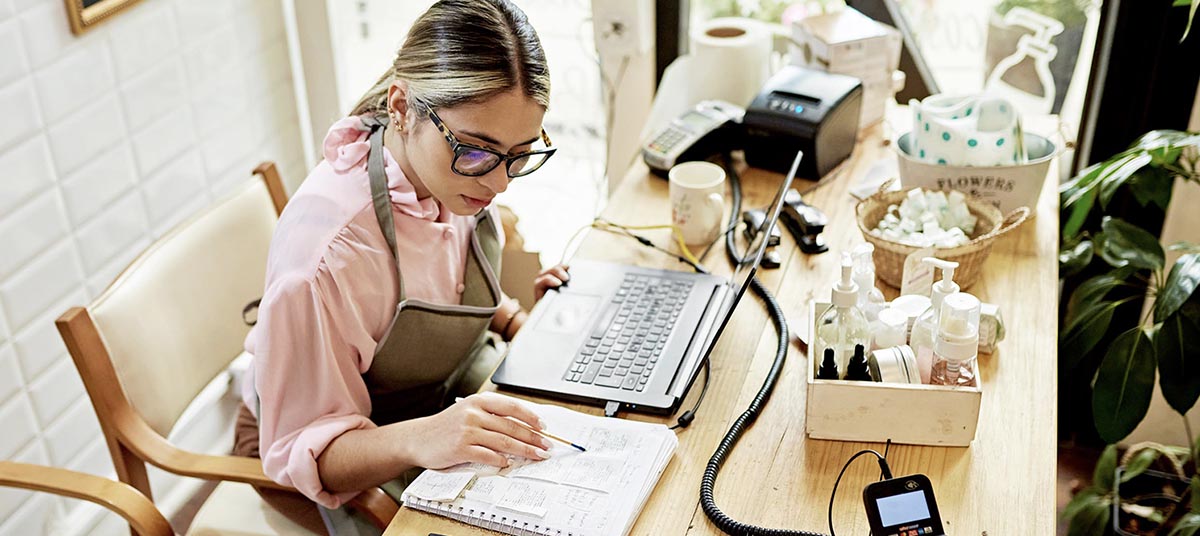Female entrepreneur reviewing notes at workspace