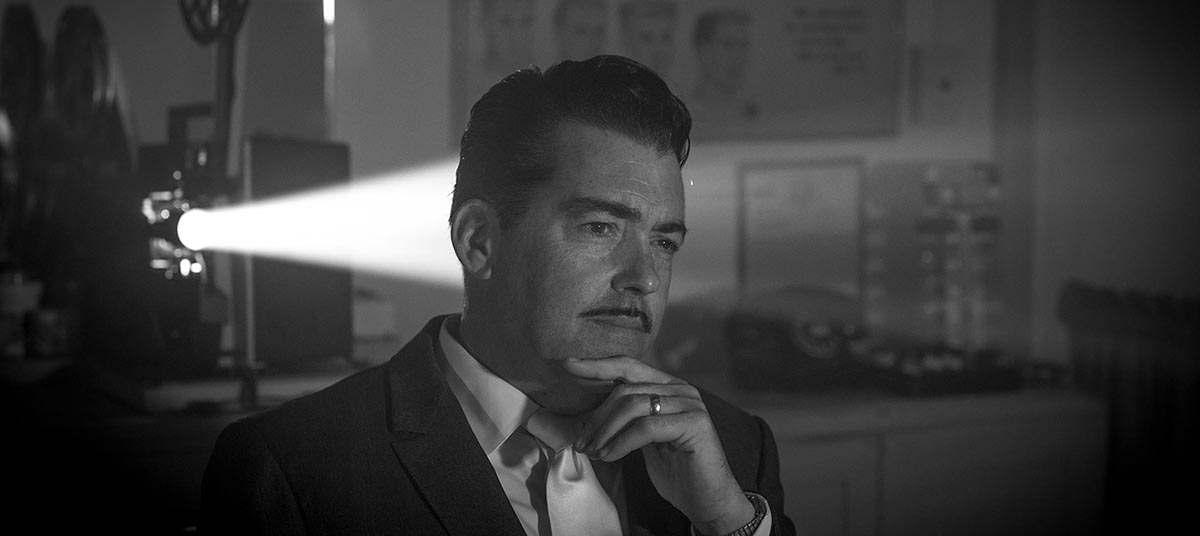 Man in suit with film projector