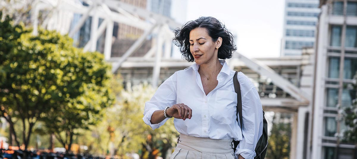 Woman checking time outdoors in city