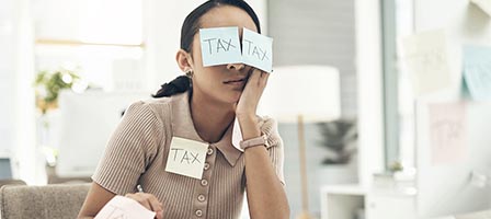 Overwhelmed person with tax sticky notes