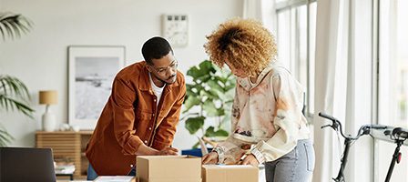 Smiling pair organizing items in boxes