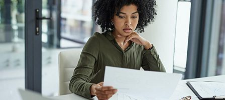 Person analyzing paperwork in office