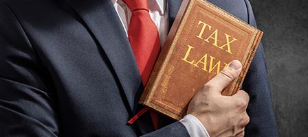 Suit and red tie with tax book