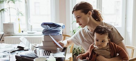 Woman working on laptop with baby