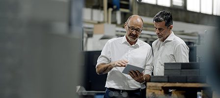 Colleagues reviewing tablet in industrial setting