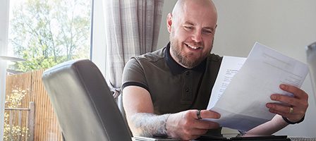 Person checking paperwork inside bright room