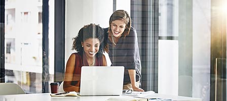 Two women collaborating at a laptop