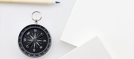 Compass and pencil on white background