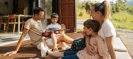Happy family relaxing outside home