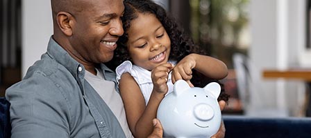 Father and daughter with piggy bank