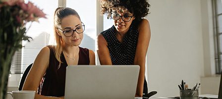 Colleagues discussing work at a desk