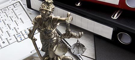 Justice statue beside computer keyboard