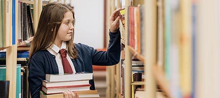 Girl selecting books in a library