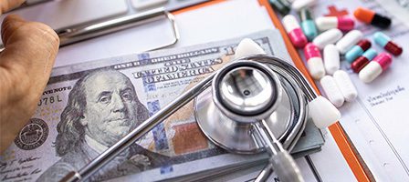 Stethoscope on money and pills