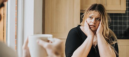 Person holding mug towards worried woman
