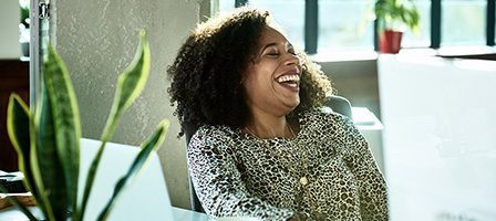 Woman laughing at office desk