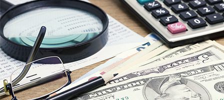 Money, glasses, and calculator on table