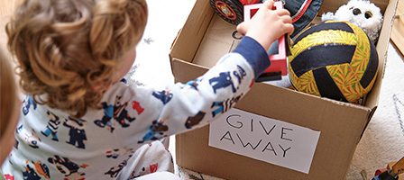Kid donating toys to charity box