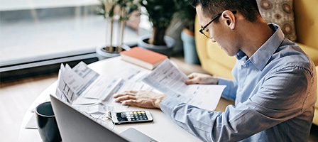 Person calculating finances with papers
